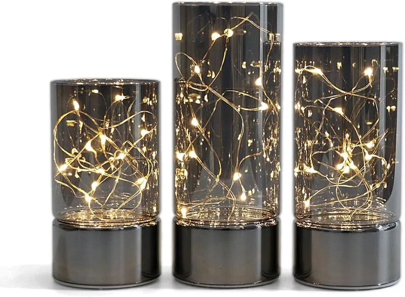 Visita la tienda de Rhytsing Rhytsing 3 Faroles Cilíndricos de Cristal Gris Diseño Clásico, lámpara LED de mesa con Guirnalda Luces LED, Velas a Pilas con Temporizador Decorativas Grandes, Alturas 12, 5, 15, 17, 5cm — Cena a la luz de velas